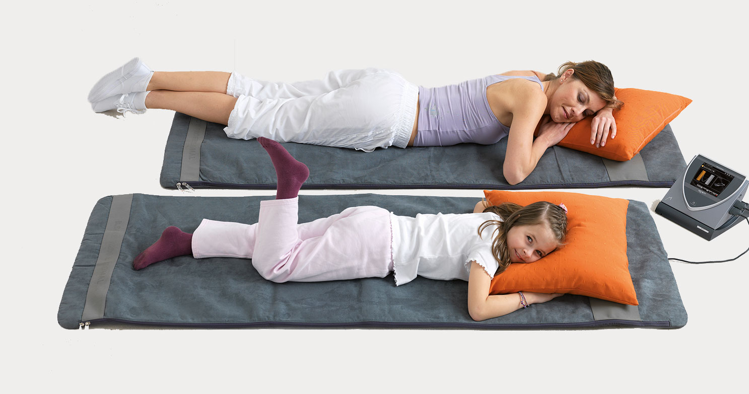 Two people lay on BEMER mats