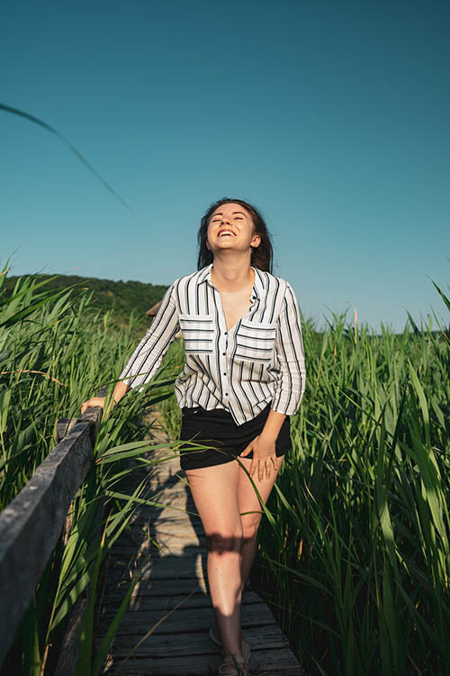 Woman happily walking through sunny field
