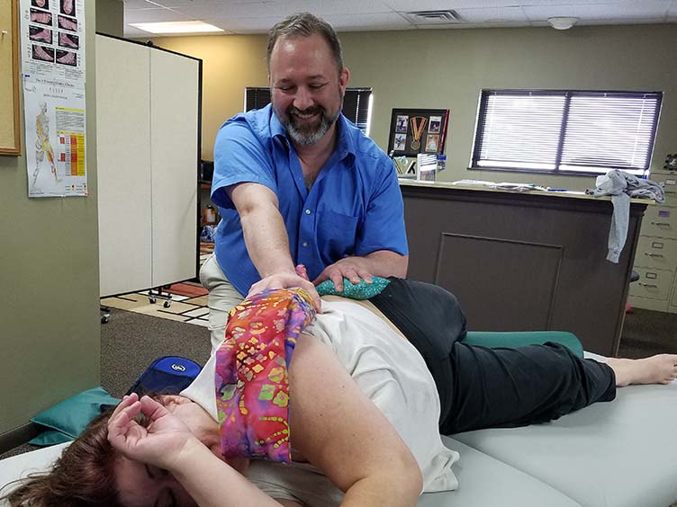 Jason Erickson demonstrates using hot flax pillow with massage to ease client's pain