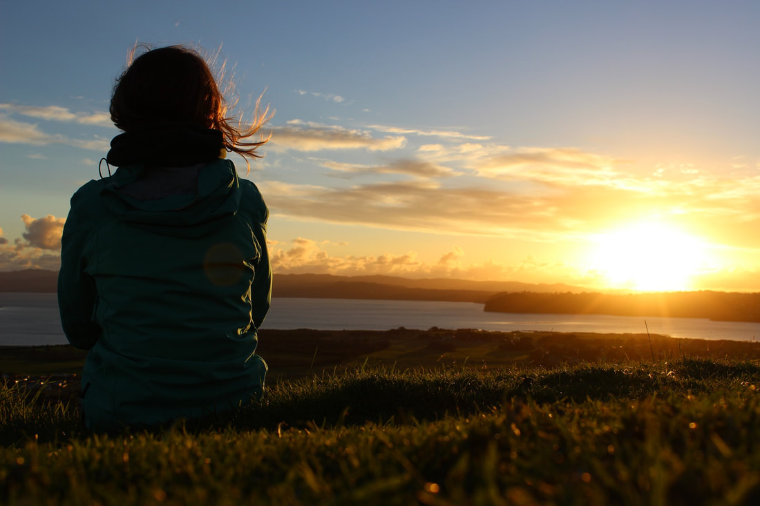 Woman meditating with sunset